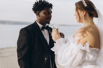 Interracial couple toasting with champagne at wedding ceremony