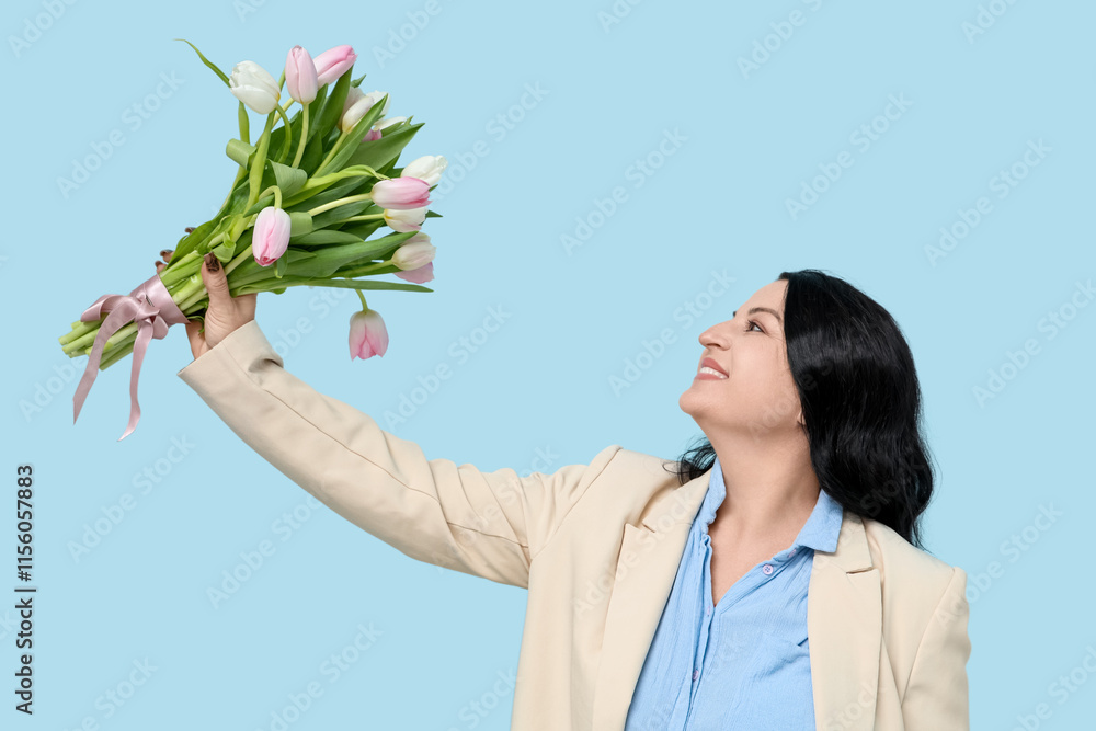 Wall mural Happy mature woman with bouquet of beautiful tulips on blue background. International Women's Day