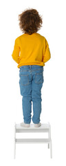 Little boy standing on step stool against white background, back view