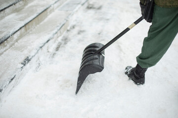 Snow shovel cleaning. Snow in yard in winter. Man cleans path from precipitation.