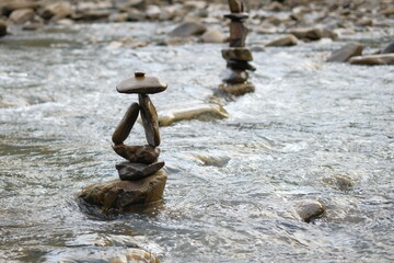 Two figures made of river stones in the middle of the stream.