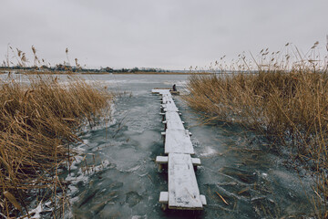 Wooden jetty on a frozen lake on a winter day