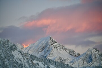 Snowcapped mountains under pink sky by sunset
