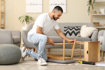 Young man assembling soft bench at home