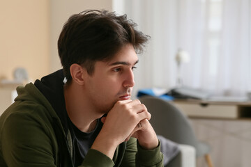 Depressed young man at home, closeup