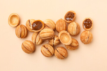 Sweet walnut shaped cookies with boiled condensed milk on beige background