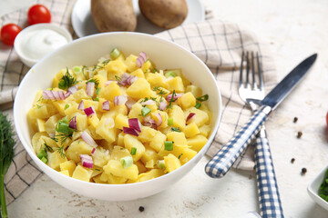 Bowl of tasty potato salad with onion on white background
