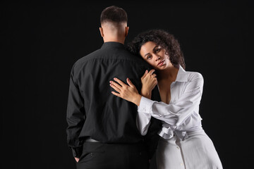 Beautiful young couple hugging on black background. Yin Yang concept