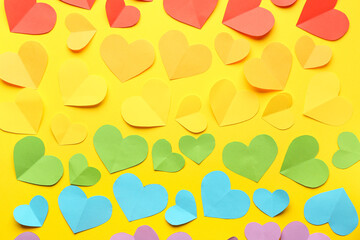 Colorful paper hearts on yellow background. Valentine's Day celebration
