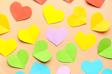 Colorful paper hearts on beige background. Valentine's Day celebration