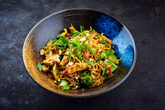 Authentical Thai mie goreng spicy stir-fried noodles with chicken and vegetables served as close-up in a Nordic design bowl