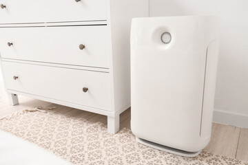 Air purifier near commode in light bedroom