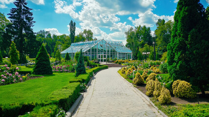 Fototapeta premium A beautiful botanical garden featuring a diverse array of exotic plants, a large glass greenhouse, and serene walking paths that invite exploration and relaxation in a lush, vibrant setting. 