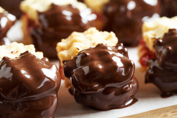 Homemade Christmas cookie filled with strawberry marmalade and dipped in chocolate
