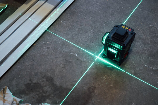 A photo of a construction site with a laser level projecting clear lines onto the ceiling.