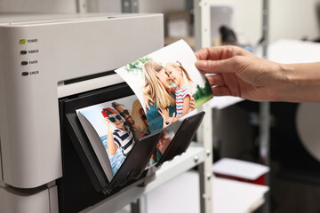 Woman with colorful photos near modern printer indoors, closeup