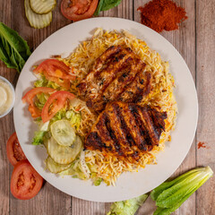 Grilled Chicken over Biryani Rice with Fresh Vegetables and Sauce

