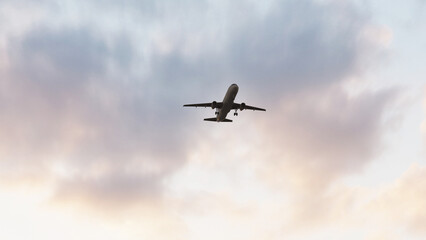 ULTRA HD. Airplane flies in sunset sky. Travel. Airplane takes off against the background of sunset sky. 