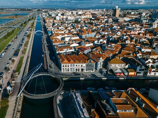 Aerail drone view of colorful rooftops line the canal in Aveiro, Portugal under a clear blue sky...