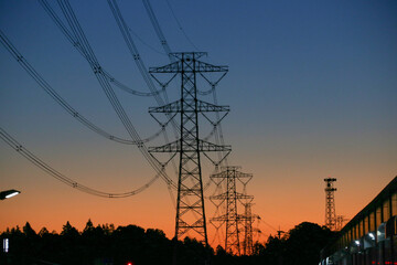 夜明けの空と高圧線