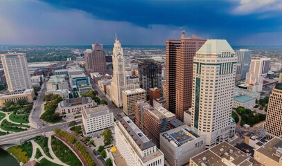 Columbus, OH skyline on a partly cloudy day. High-rise buildings and city streets are visible. DOWNTOWN, COLUMBUS, OHIO, UNITED STATES
