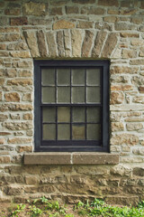Rustic Stone Wall with Vintage Window: A Glimpse into Architectural History.
