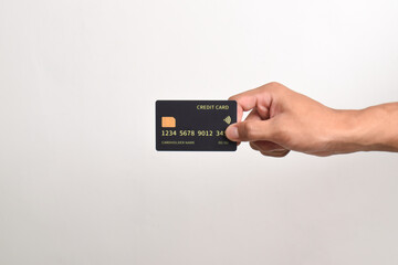 Hand holding black credit card isolated on white background.