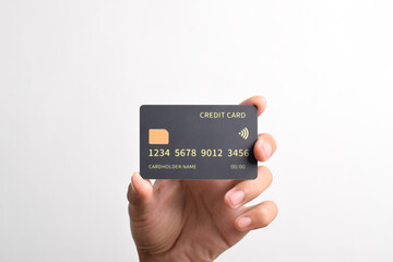 Hand holding black bank credit card with chip isolated on white background.