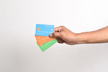 Hand is hold three credit cards. Blue, green and orange credit cards isolated on white background.