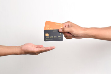 Hand holding two credit cards and other hand receiving isolated on white background.