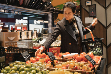 Woman Selecting Fresh Fruits and Vegetables in a Modern Grocery Store