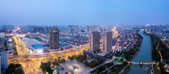 Fototapeta premium Vibrant Cityscape at Dusk Overlooking Urban Development and Waterway