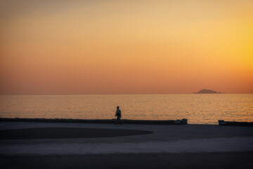 Fototapeta premium Tranquil Sunset Stroll Along the Water's Edge