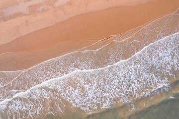 Serene Aerial View of Gentle Waves Meeting Sandy Shoreline