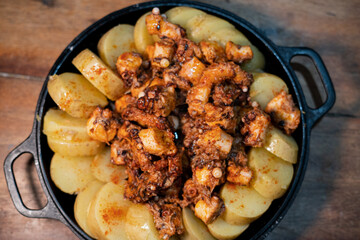 Galician-style Octopus served in black iron pan, top-down view
