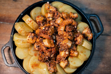 Galician-style Octopus served in black iron pan, top-down view
