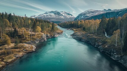 Drone high-angle photo of the turquoise-colored mountain river flowing in the pine woodland with a view of the mountain peaks in the background in Innlandet County, Norway
