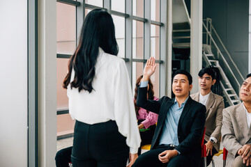 In the midst of a conference, a young man eagerly raises his hand to pose a question. The group...