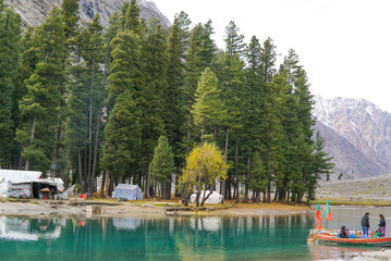 Scenic forest campsite by a tranquil mountain lake in Mahodand Lake which is located in Kalam, Pakistan, surrounded by tall pine trees and natural beauty. 