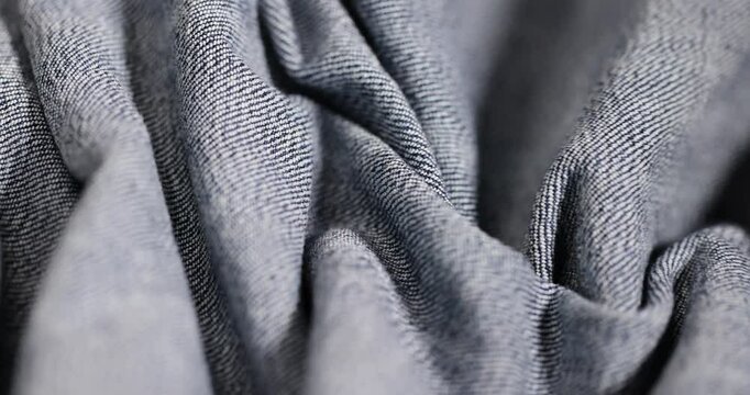 new blue denim fabric for the production of clothing and other items , crumpled fabric, the details of a piece of sturdy denim fabric for the production of clothing