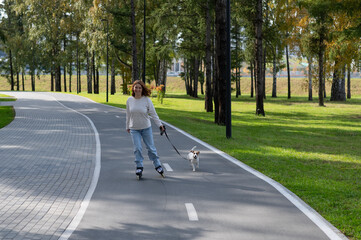 Caucasian woman roller skating with her jack russell terrier dog in park. 