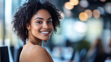 Obraz premium Confident and Radiant: A young woman with a radiant smile and beautiful, curly hair looks over her shoulder, exuding confidence and natural beauty.