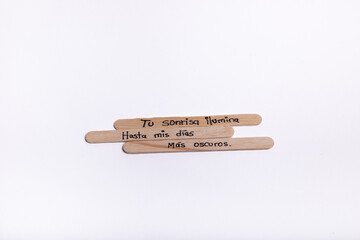 A wooden stick with a message written on it in Spanish