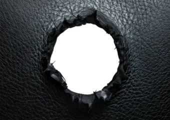 Hole in black leather with frayed edges isolated on a transparent or white background