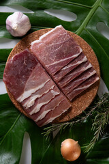 fresh raw pork shoulder sliced for grilling on a wooden plate