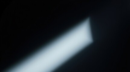 Light Leak Abstract:  A dramatic, blurred light beam cuts through an otherwise dark space, creating an abstract and moody atmosphere. Perfect for backgrounds or design elements. 
