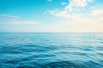 Obraz premium Serene ocean scene with calm waves under a bright blue sky, perfect for relaxation and travel themes.