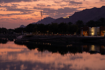 Naklejka premium Hatta, a mountain village in the Hajar Mountains, offers breathtaking views. This picture captures the serene morning beauty of Hatta with a stunning reflection on Leam Lake.