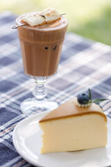 Cup of delicious chocolate with s'more marshmallows on checked pattern table