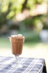 Cup of delicious chocolate with s'more marshmallows on checked pattern table